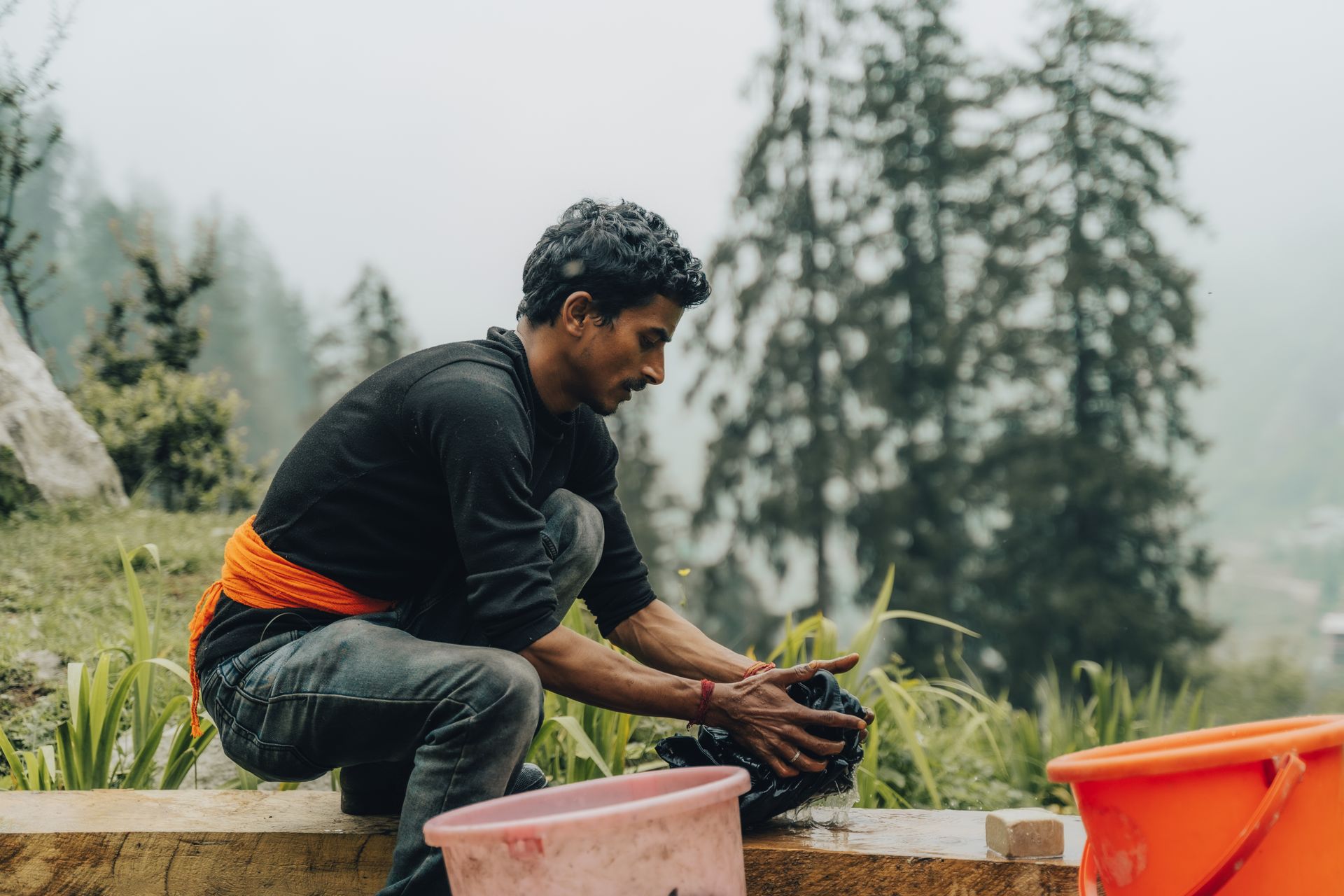 Man Kneeling and Washing Clothes