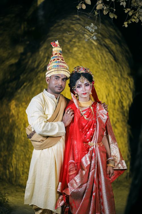 Free A traditional Indian couple posing in ceremonial attire in an outdoor setting. Stock Photo