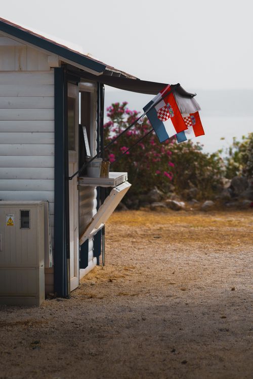 Free A cabin by the sea adorned with flags, featuring summer atmosphere. Stock Photo