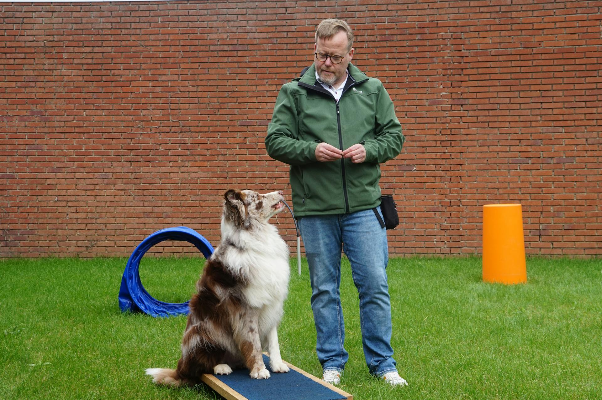 A man standing next to a dog on a ramp