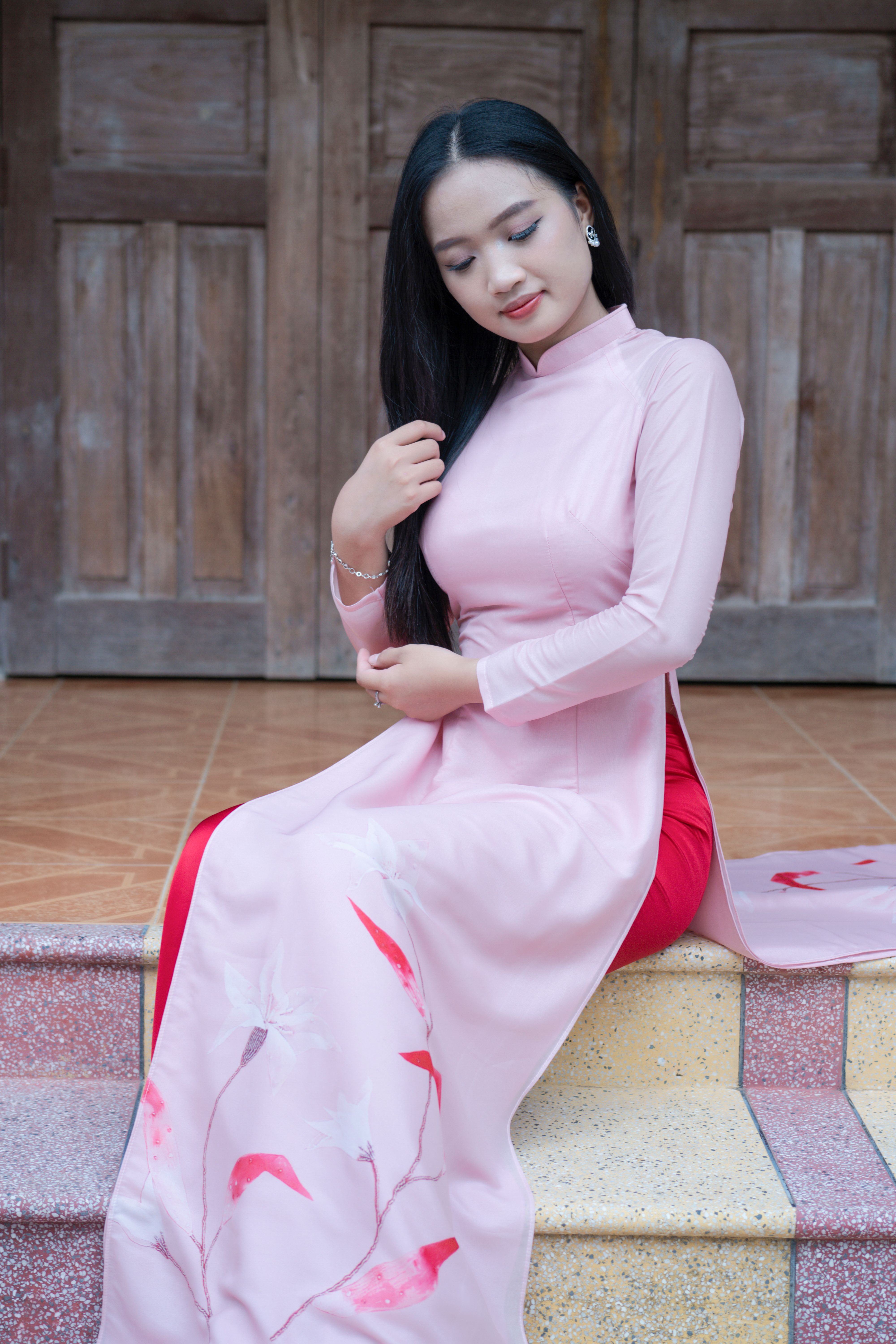 A woman in a pink dress sitting on steps · Free Stock Photo