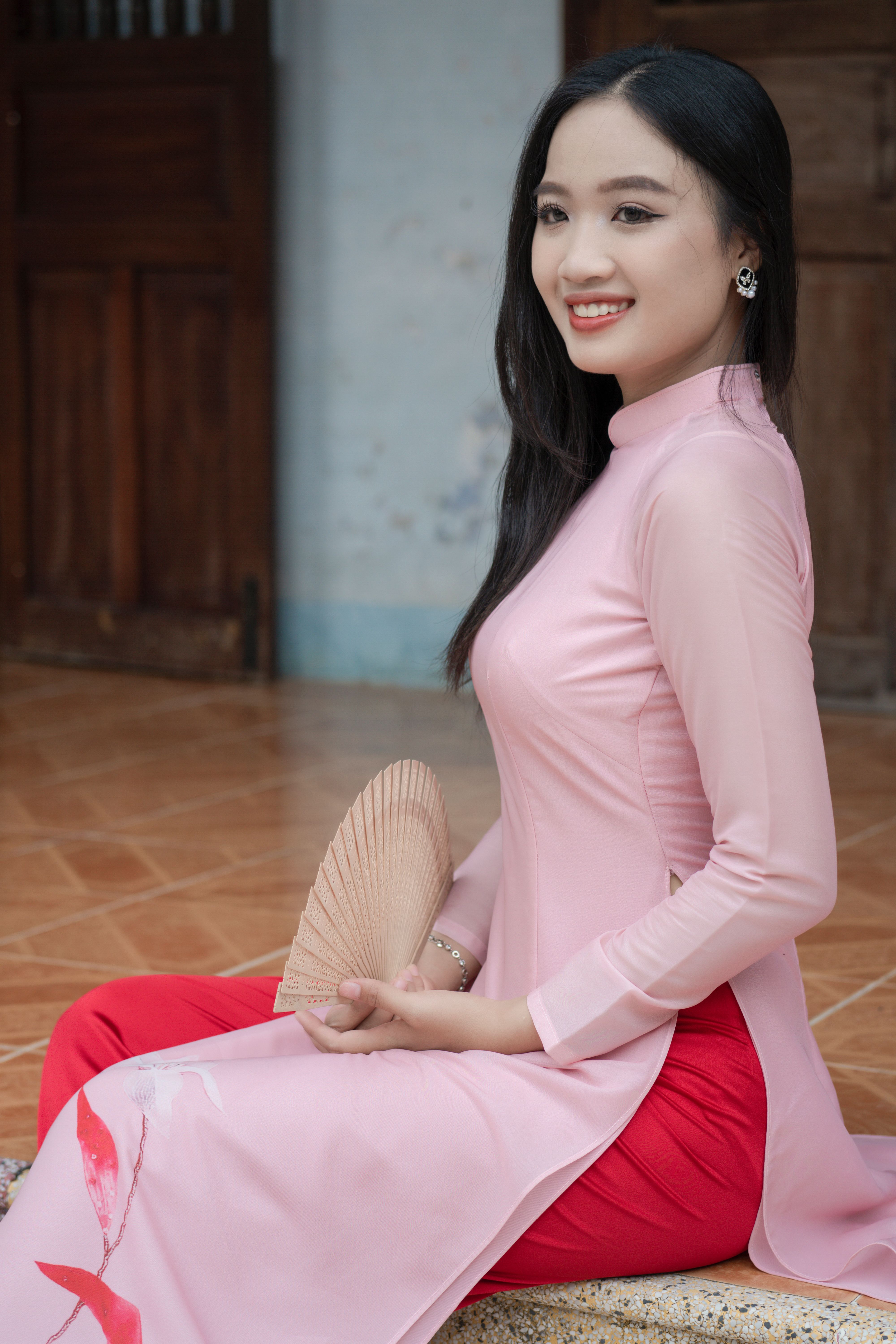 A woman in pink and red sitting on the floor · Free Stock Photo