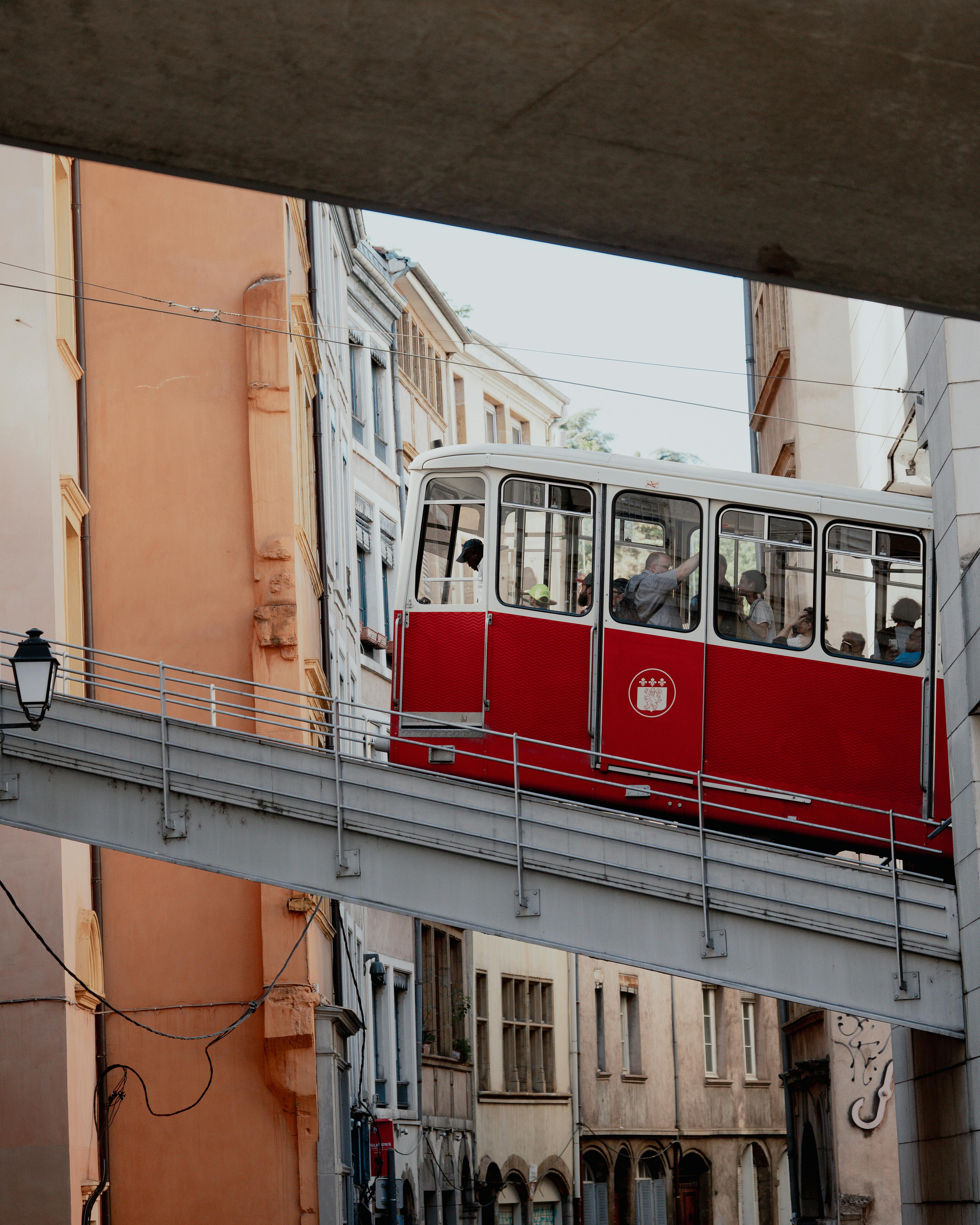 Vintage red tram navigating a European city street, highlighting urban transport heritage.