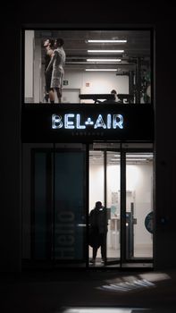 Neon-lit entrance to Bel-Air fitness center in Lausanne at night.