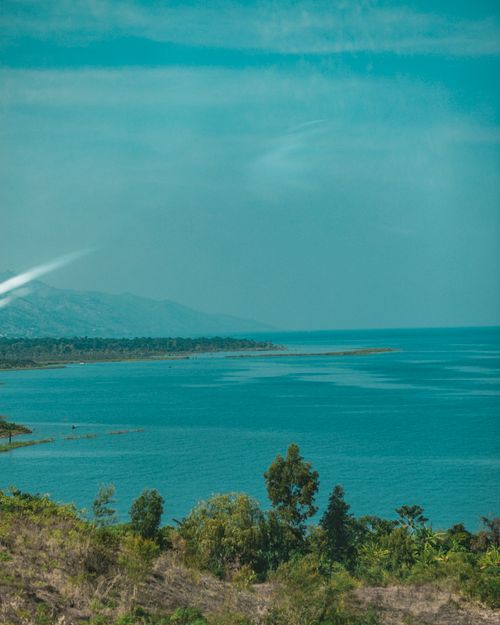 Free A vibrant lake view with clear skies, lush greenery, and serene waters, perfect for travel inspirations. Stock Photo
