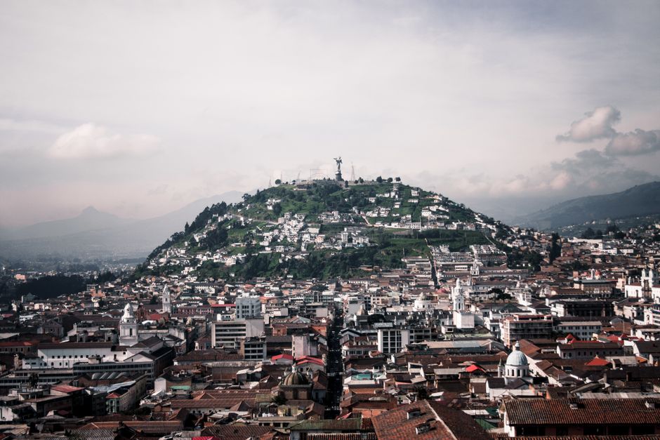Aerial view of Quito featuring Panecillo Hill and Virgin statue, capturing historic architecture and vibrant cityscape.