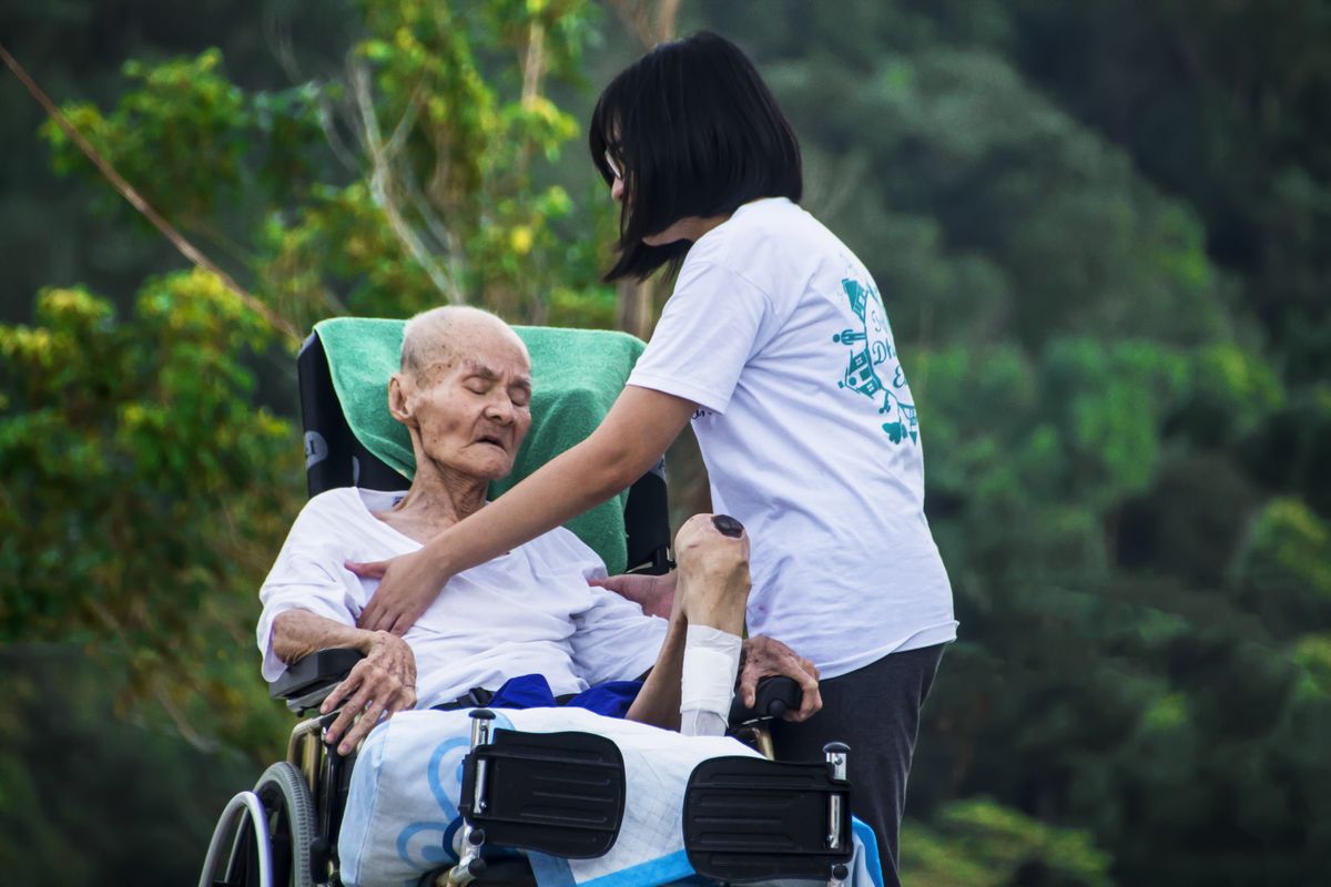 Caregiver supporting elderly resident in a warm London care home environment