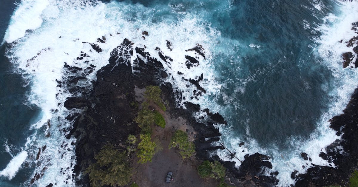 Photo by Jashith G Dramatic aerial shot of the rugged coastline in Maui, Hawaii, showcasing powerful ocean waves against dark rocks.