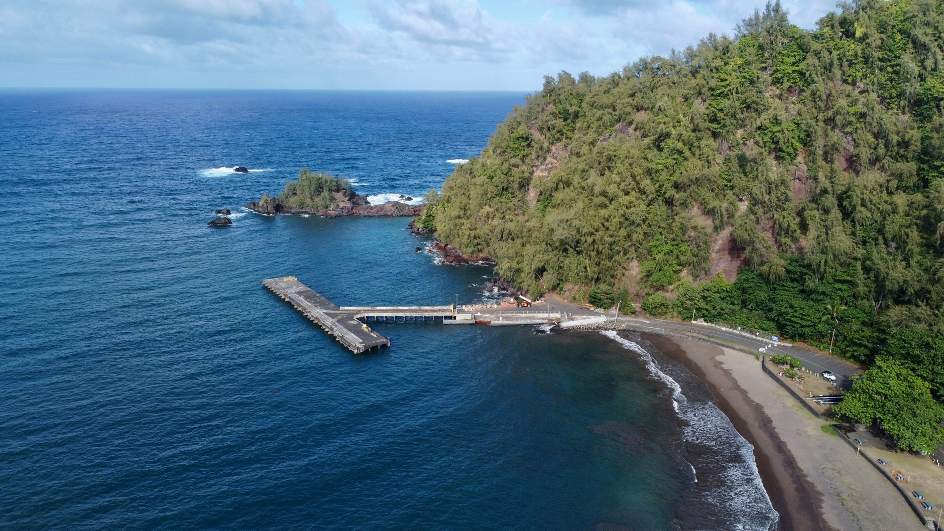 Stunning aerial view of Hana Bay in Hawaii featuring lush greenery and vast ocean.