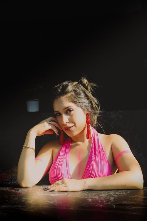 Free Portrait of a woman in a pink dress with red earrings, exuding elegance and style. Stock Photo