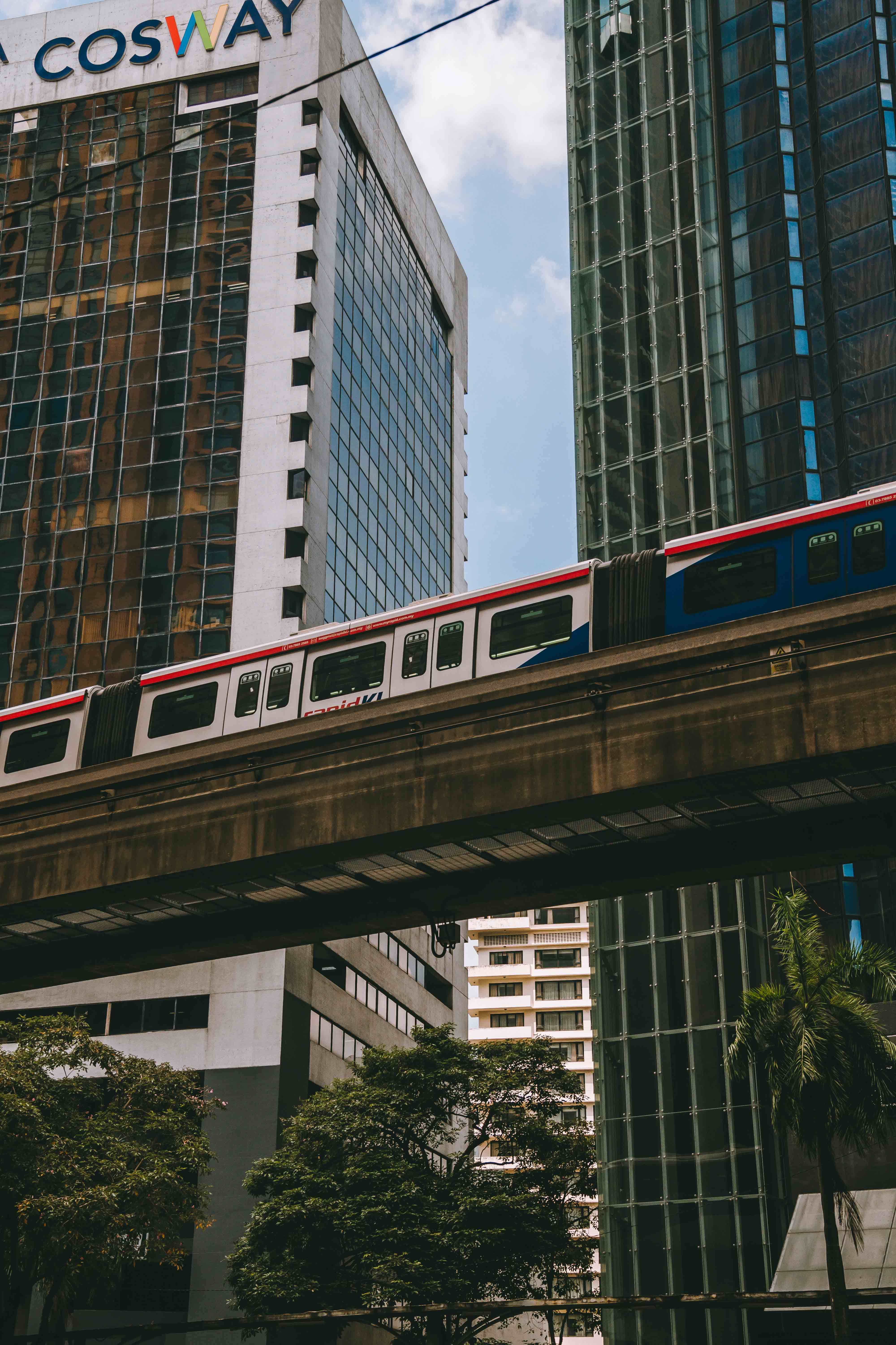 A train traveling through a city with tall buildings · Free Stock Photo