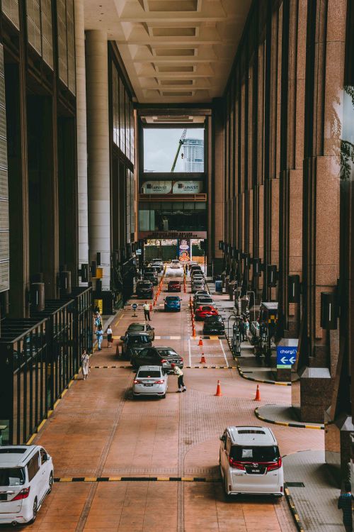 Free A bustling urban driveway in Kuala Lumpur featuring modern architecture and vehicles. Stock Photo