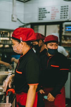 Chefs working diligently in a bustling Kuala Lumpur restaurant kitchen.