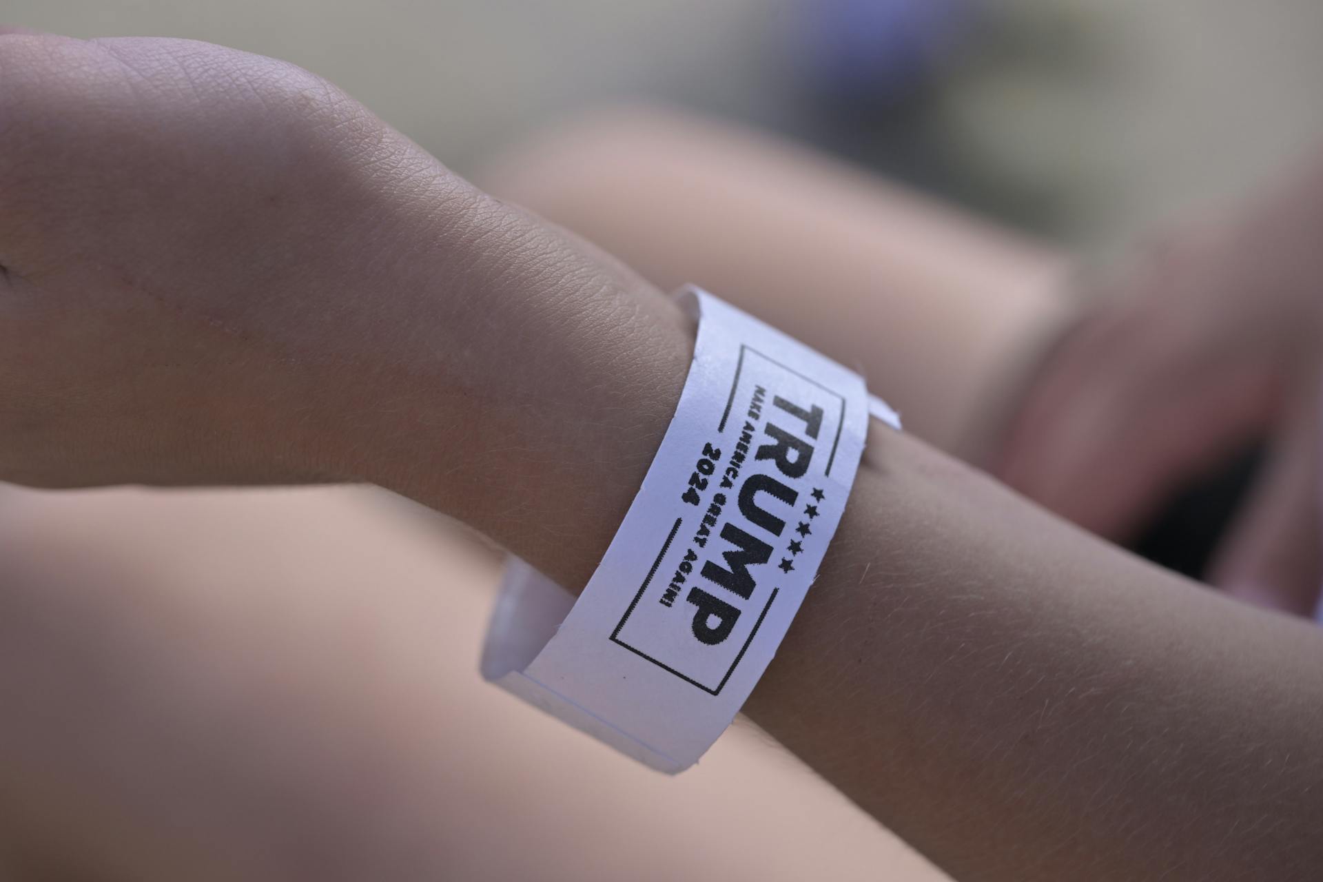 A close-up of a wristband showing political support for 'TRUMP 2024.'