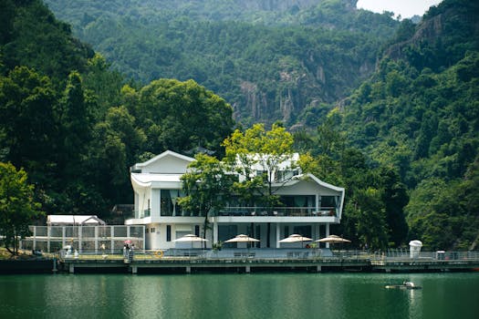A contemporary house by a serene lake surrounded by lush greenery and mountains in Wenzhou, China.
