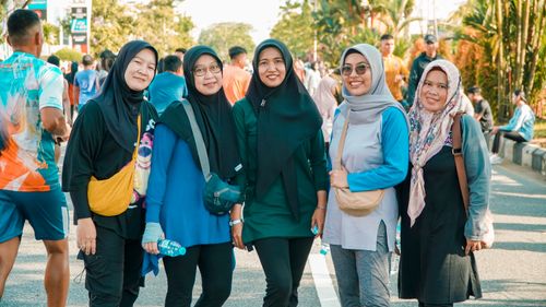 Free A group of women in hijabs smiling outdoors at a public event, showcasing cultural diversity and unity. Stock Photo