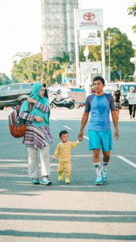 A family enjoys an outdoor walk in Pontianak's urban setting, capturing the essence of daily life. - Fotografer Sidoarjo