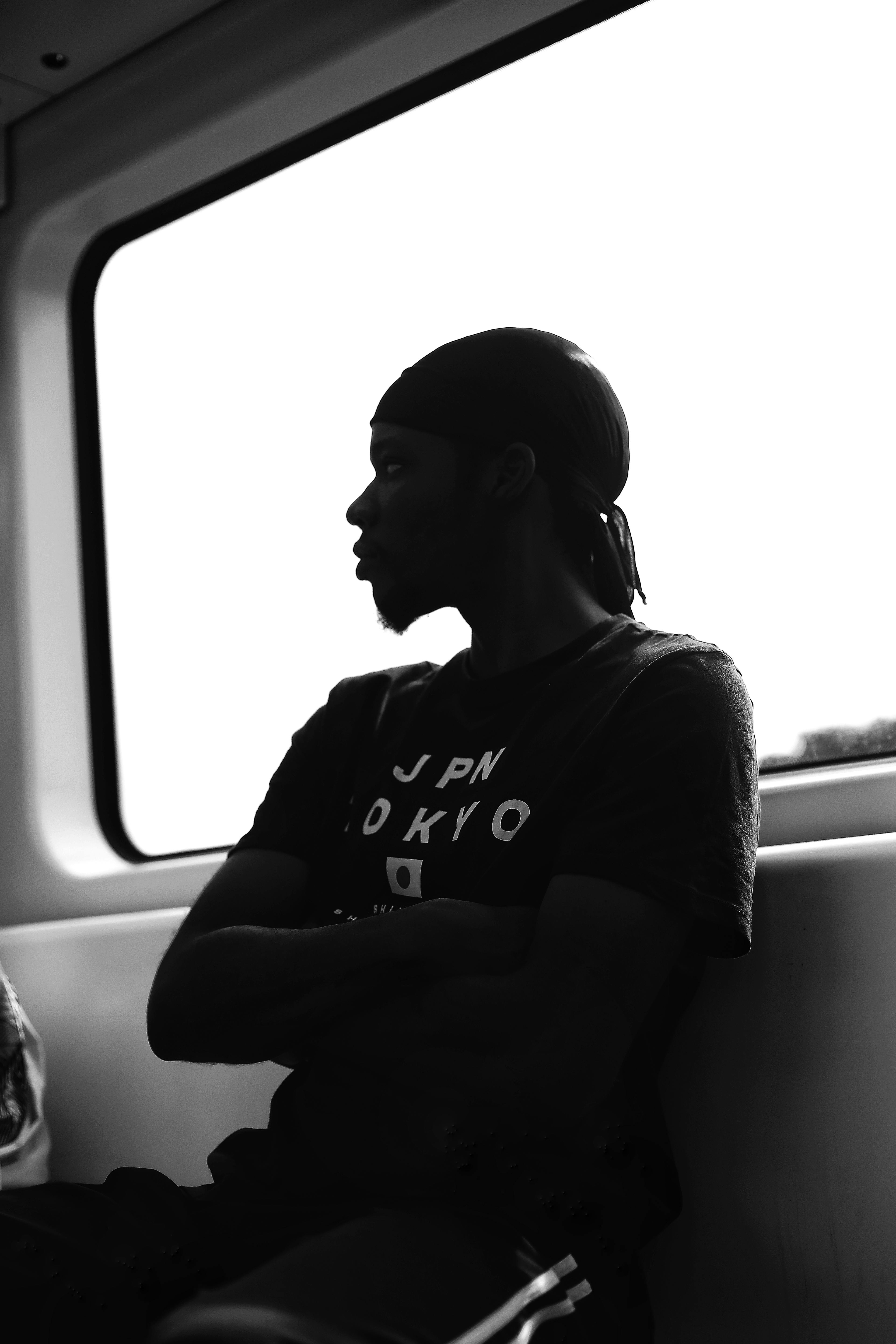 Black and white silhouette of a man sitting inside a public transportation vehicle in Abuja, Nigeria.