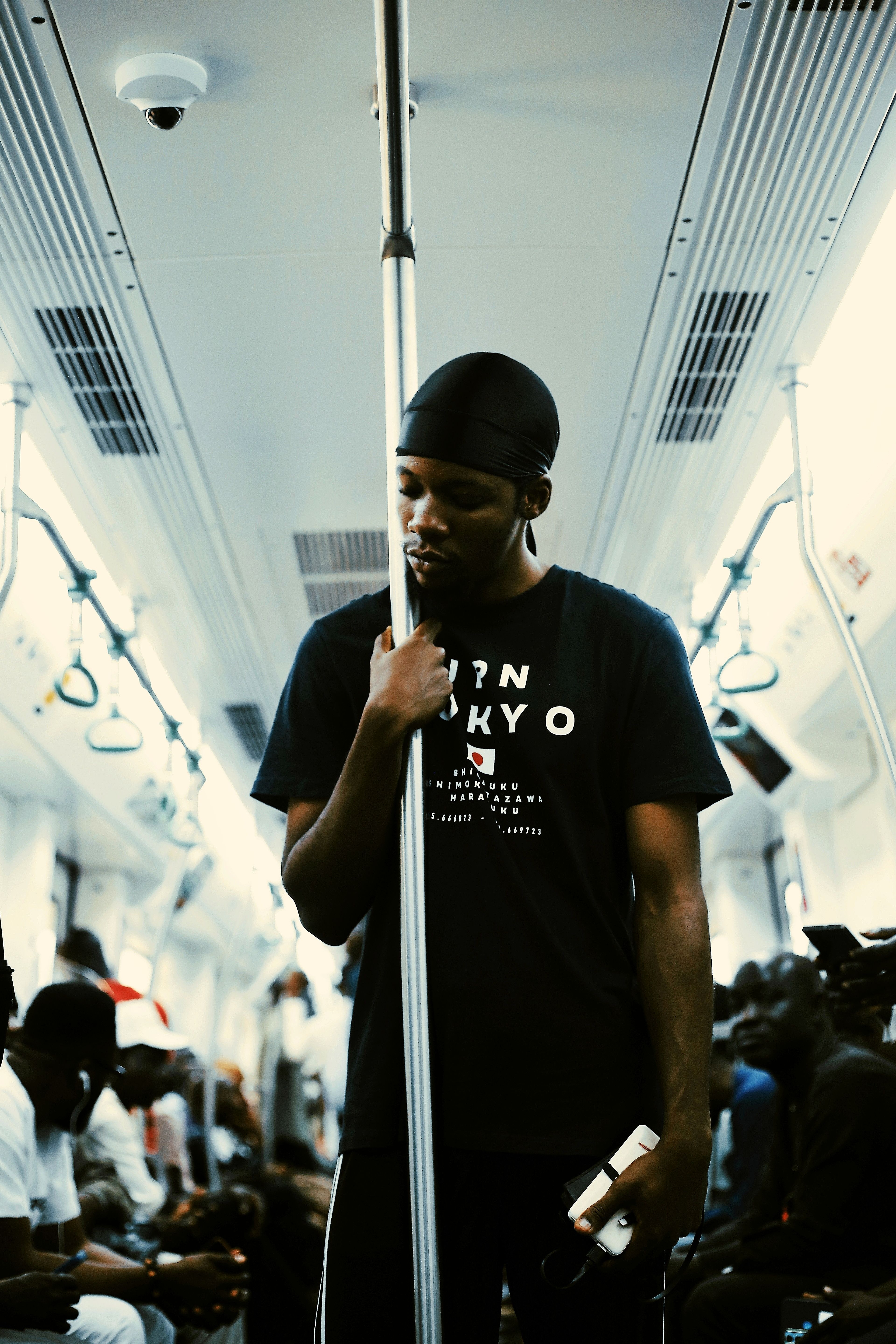 Young man standing in crowded subway train in Abuja, Nigeria. Capturing urban transit life.
