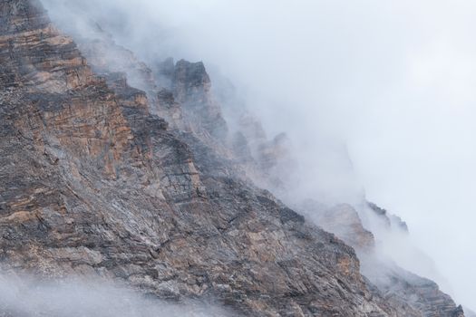 A dramatic misty view of mountain peaks shrouded in clouds during winter.