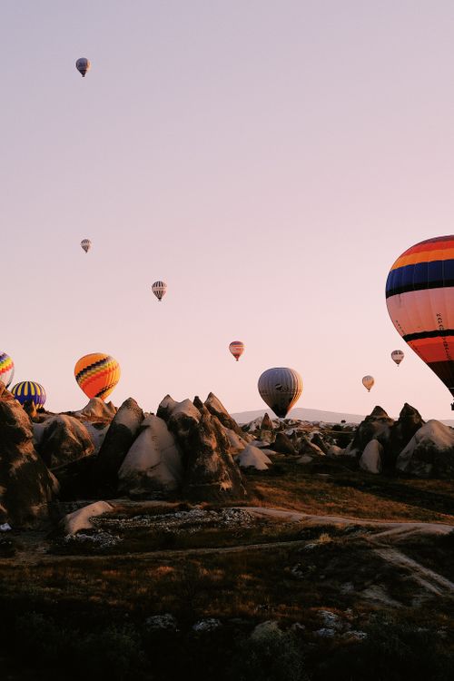 Free A serene view of hot air balloons floating over Cappadocia's unique rock formations at sunrise. Stock Photo