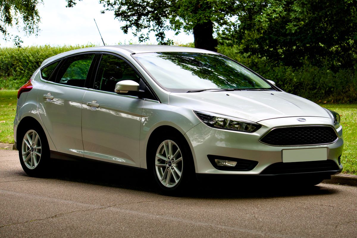 Silver compact hatchback parked on a tree-lined road — photo by Mike Bird on Pexels