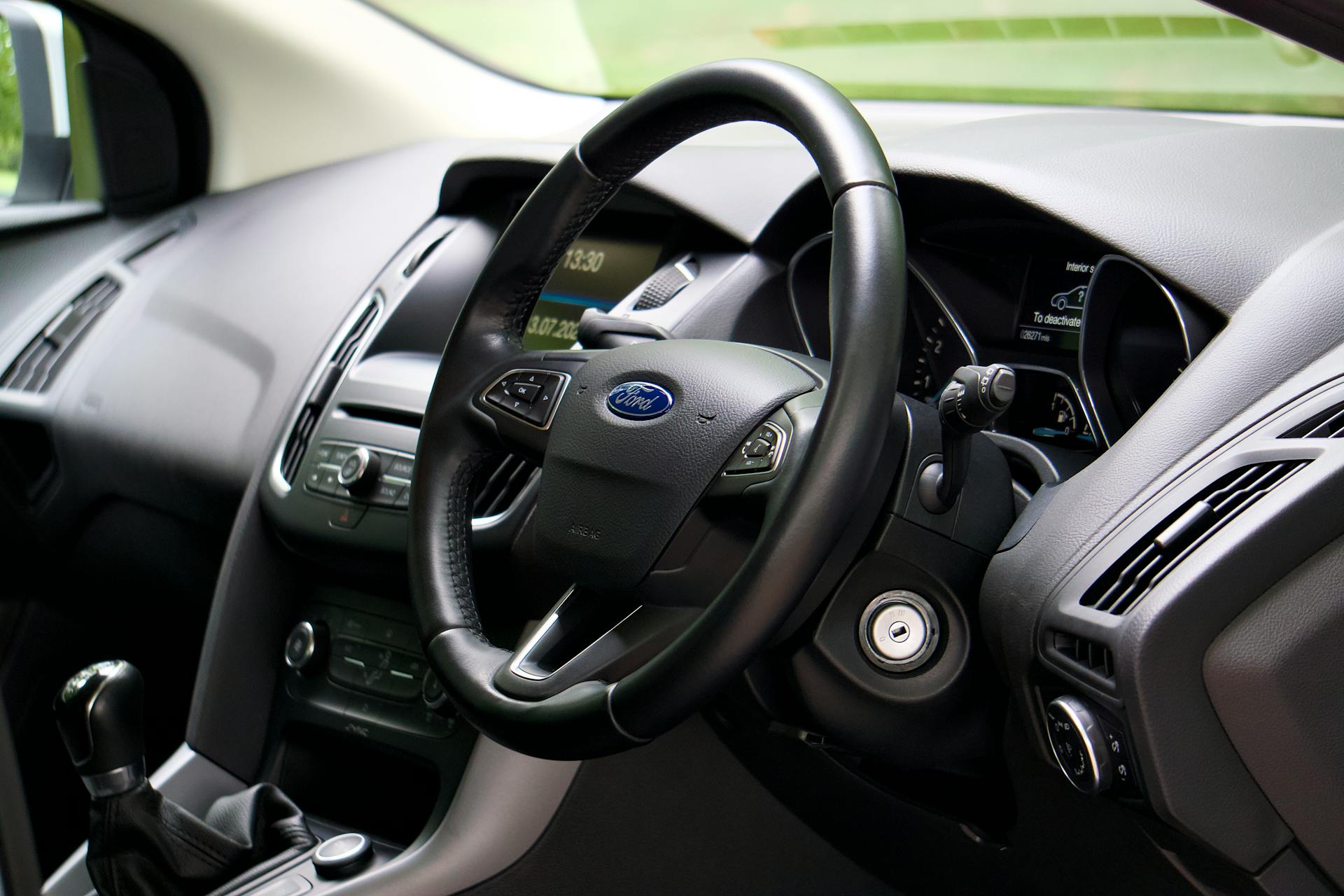 Close-up of a modern car interior showcasing the steering wheel and dashboard details.