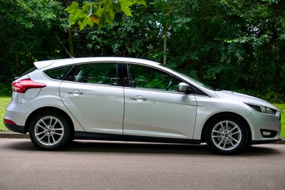 Side view of a white hatchback parked on a sunny street — photo by Mike Bird on Pexels