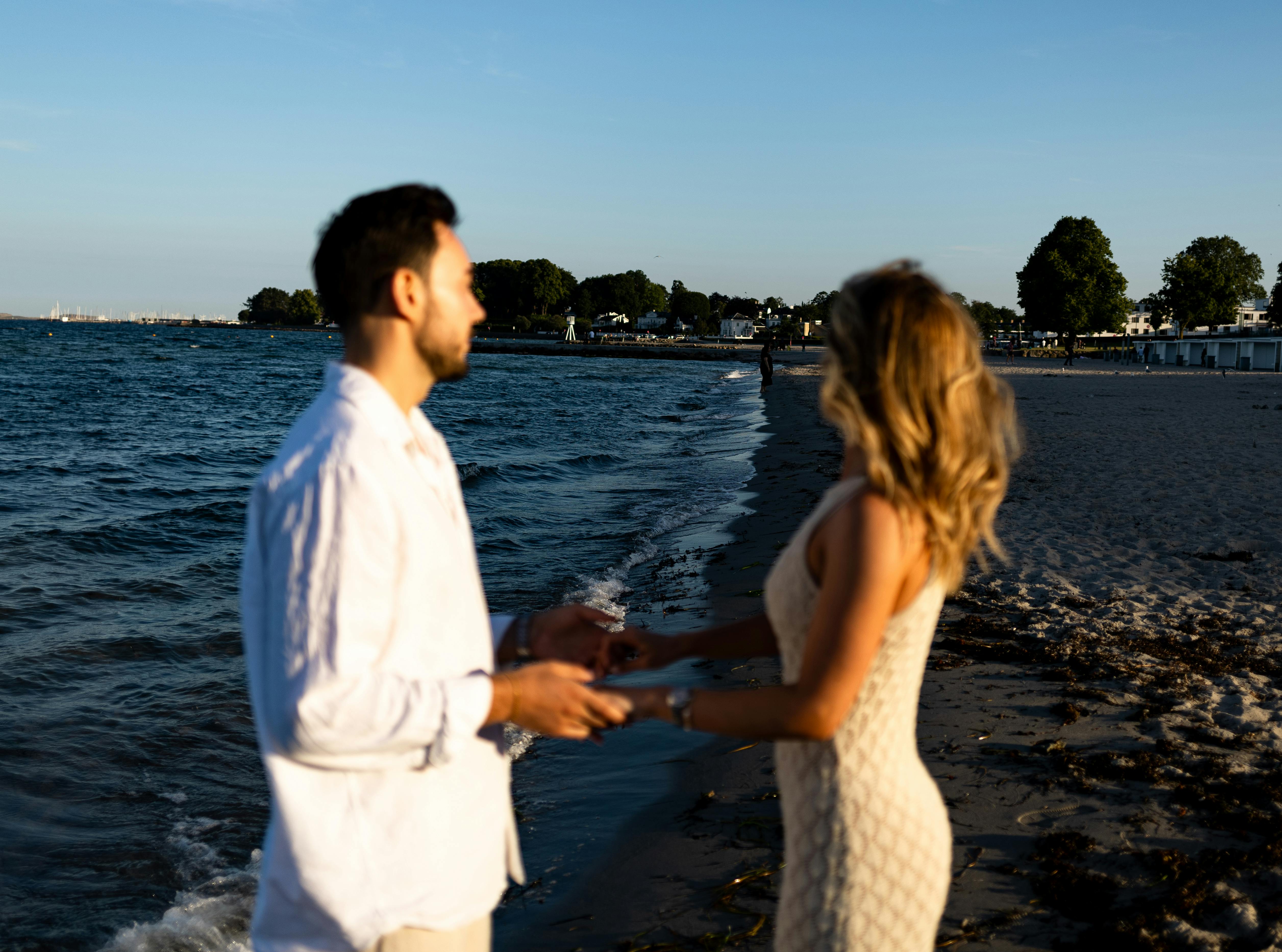 a couple holding hands on a beach