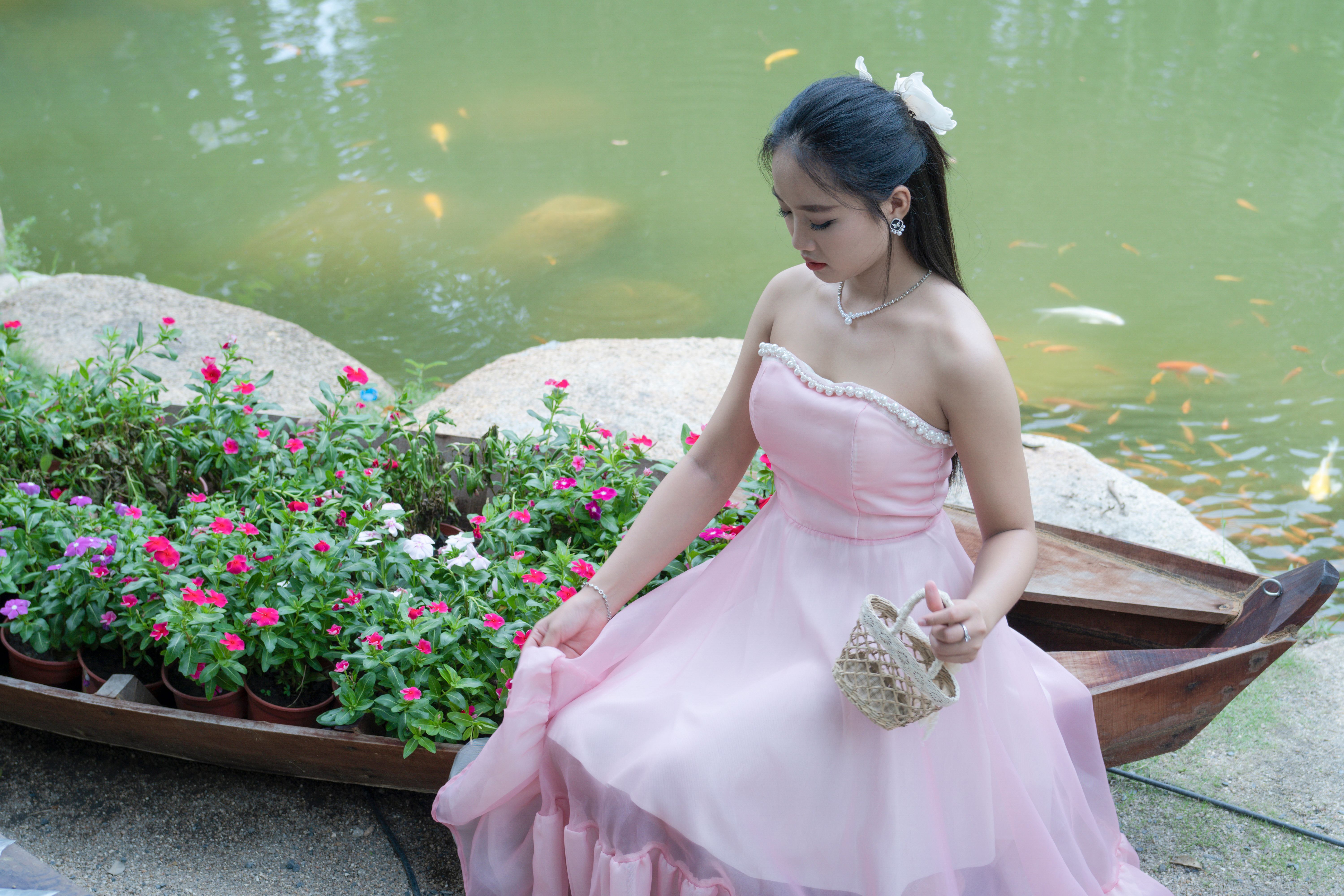 An Elegant Woman in a Pink Dress Sitting by the Pond · Free Stock Photo