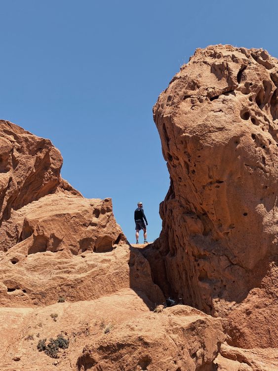 Man Standing between Arid Rocks · Free Stock Photo