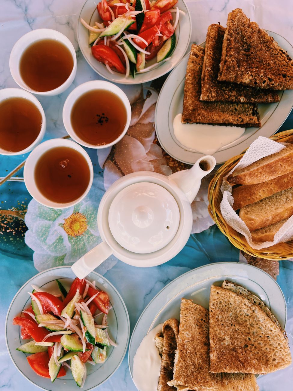 A delicious brunch featuring toast, fresh salads, and tea, perfect for a cozy meal.