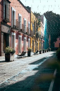 Colorful narrow street with traditional architecture in Puebla de Zaragoza, Mexico, reflecting vibrant Mexican culture.