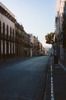 Peaceful urban street scene in Puebla, Mexico, captured at dawn featuring historic architecture.