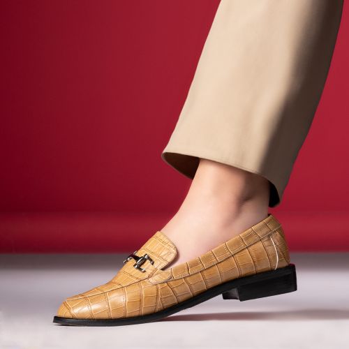 Free Stylish tan leather loafer with textured design on a vibrant red backdrop. Stock Photo