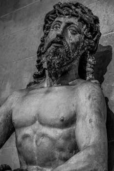 Black and white photo of a stone Jesus Christ sculpture displaying Renaissance art style.