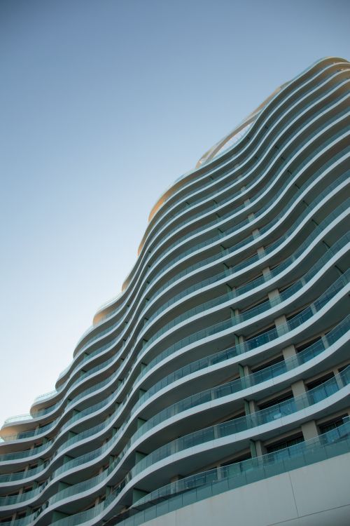 Free Elegant contemporary skyscraper with curved lines in Limassol, Cyprus against a blue sky. Stock Photo
