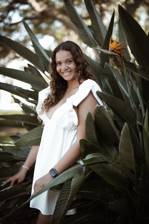 Free Fashion portrait of a smiling woman in a white dress amidst tropical foliage at New Smyrna Beach, Florida. Stock Photo