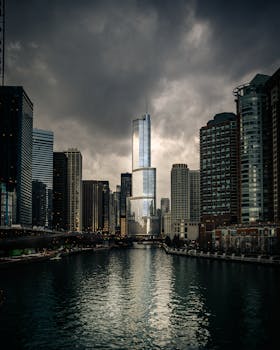 Moody downtown Chicago skyline featuring towering skyscrapers and reflections on the river.