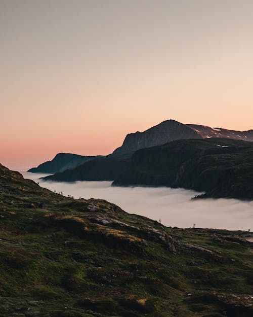 Mountain and hills with dense fog in hollow at sunset