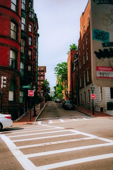 Picturesque urban street scene with historic brick buildings and lush greenery in daylight.