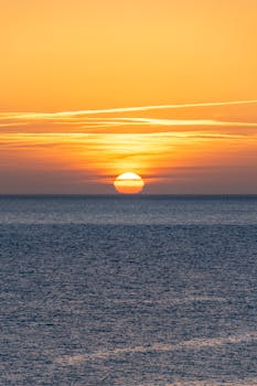 A breathtaking sunset view over the ocean in Ciudadela, showcasing vibrant colors and serene waters.