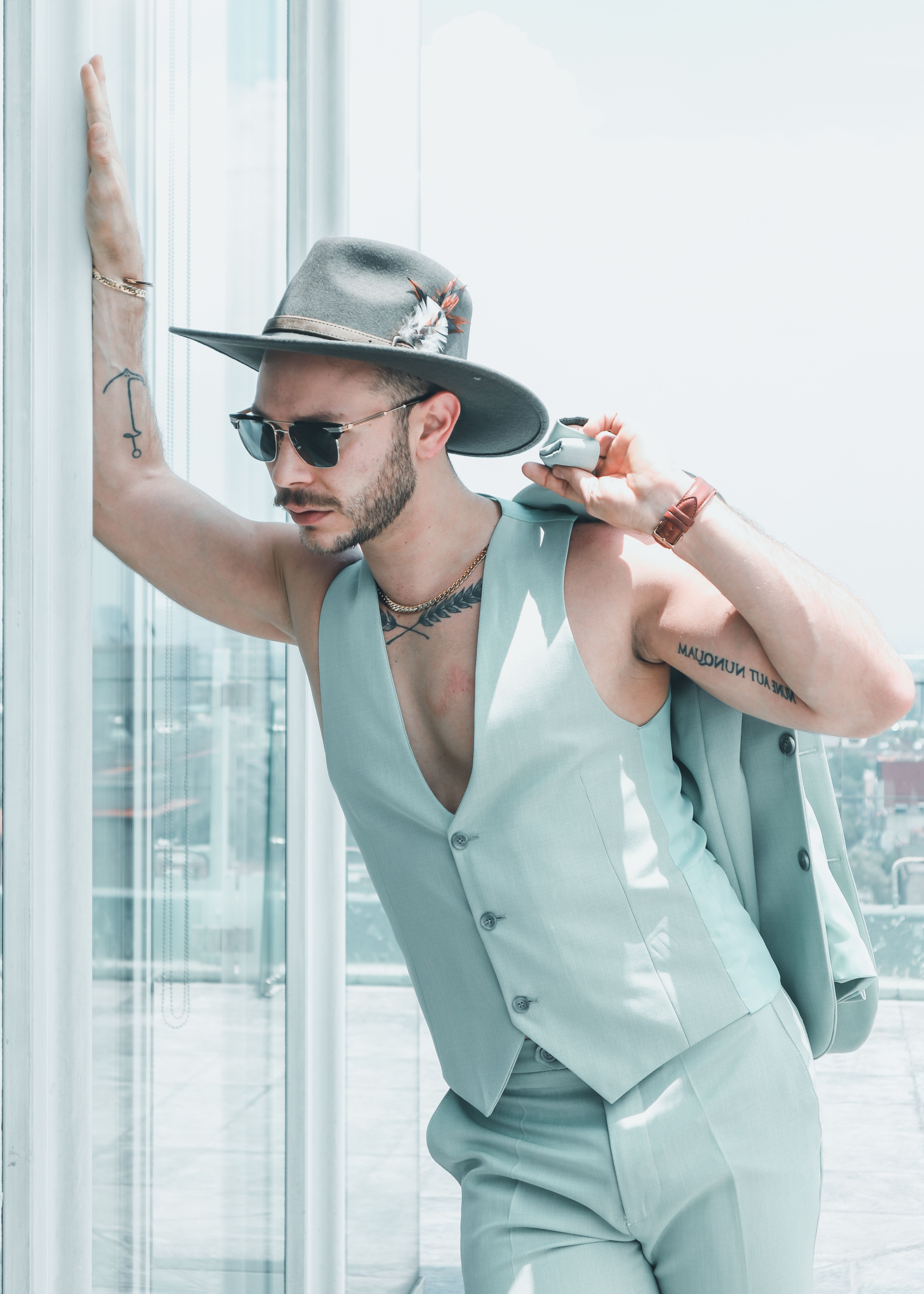 Chic portrait of a man in sunglasses and fedora, capturing modern summer style.