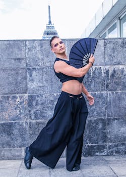 A striking urban dance portrait featuring a person in modern fashion holding a fan.