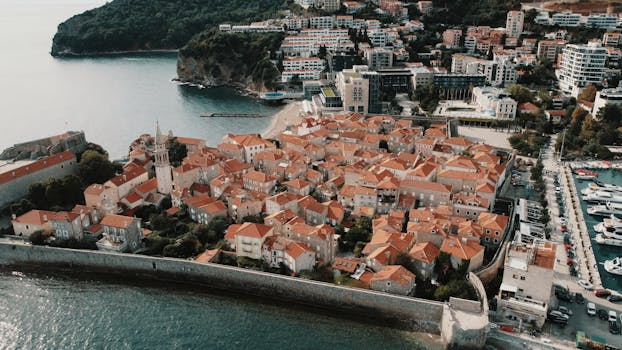Stunning aerial view of Budva Old Town in Montenegro with red roofs and coastline.