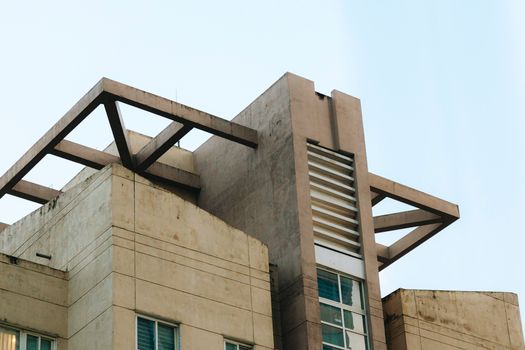 Modern concrete building with unique angular design elements against a clear sky.