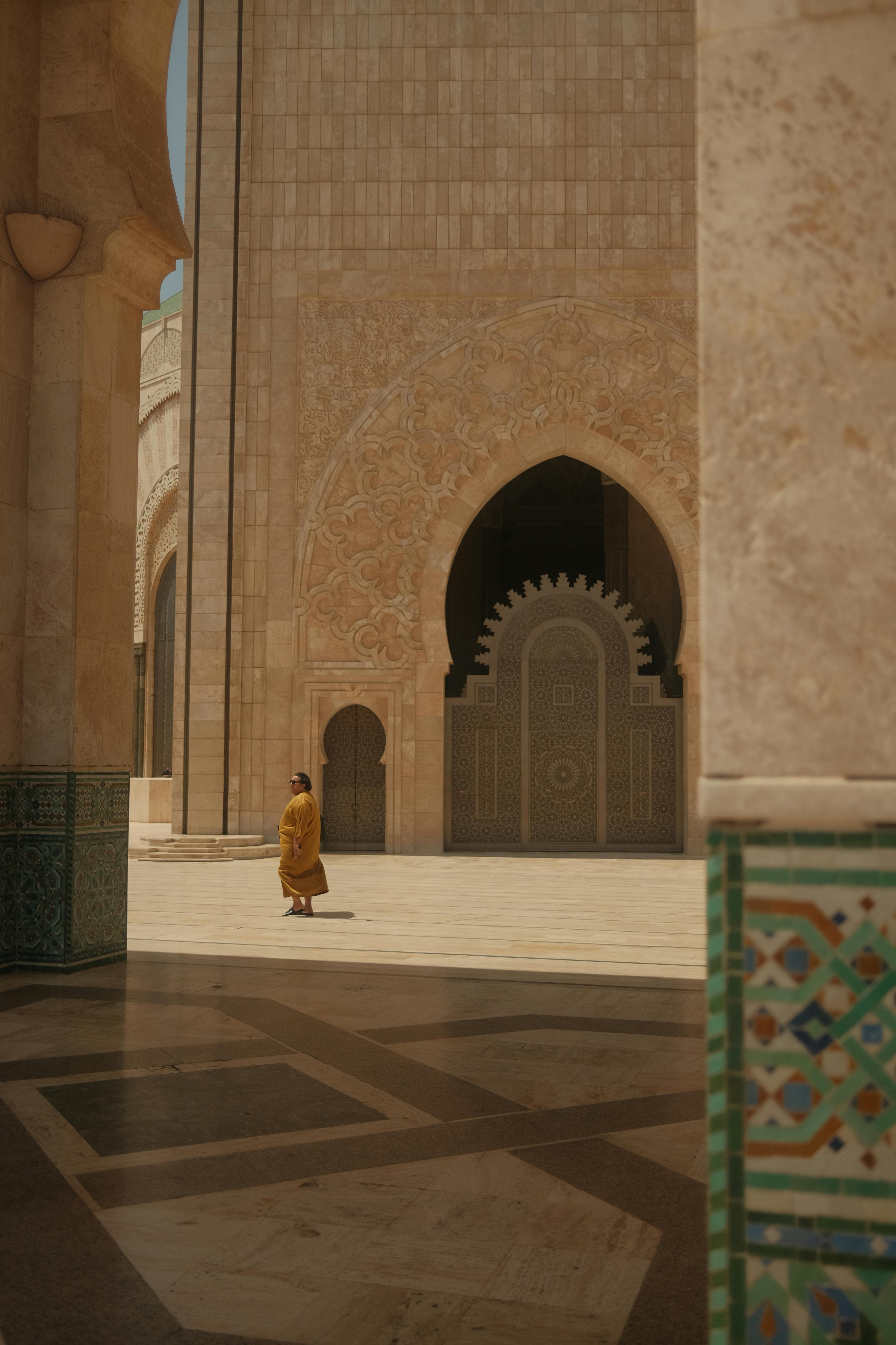 A man walking through an archway in a mosque