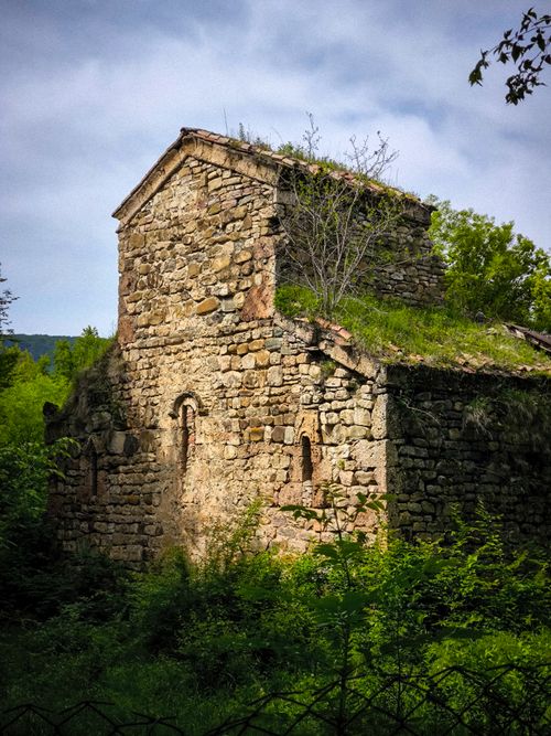 Free Explore an ancient medieval stone church surrounded by verdant greenery, showcasing Gothic architecture. Stock Photo
