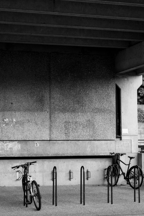 Free Minimalist black and white photo of bicycles parked in an urban French setting. Stock Photo