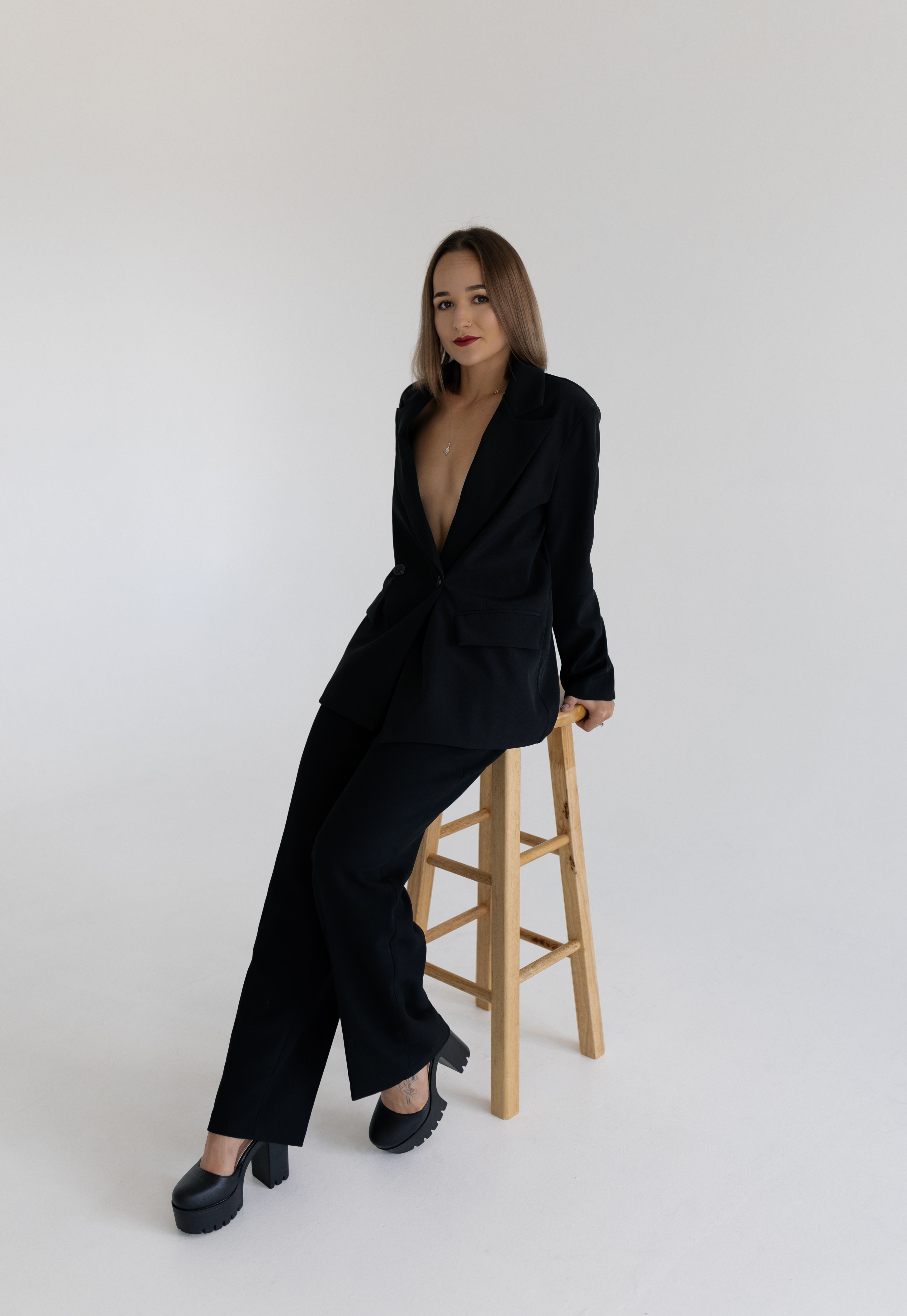Woman Wearing Black Suit Posing in a Studio · Free Stock Photo
